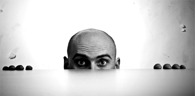 Bald Man Peering Over Tabletop