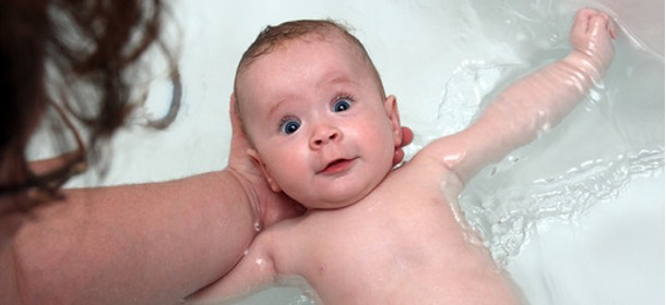 Baby in bath, startled look